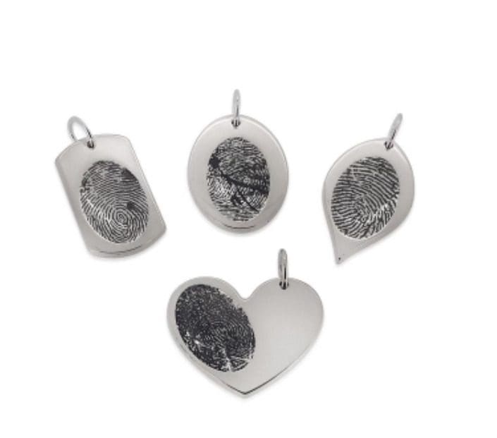 A group of four silver pendants with one showing the fingerprint.