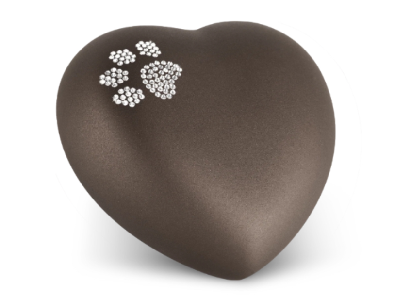 A heart shaped urn with a paw print on it.